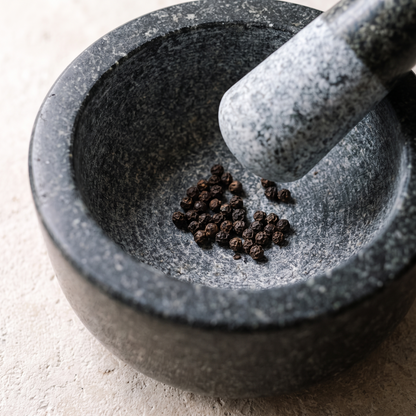 Looking down into the coarse granite grinding surface with whole peppercorns in the bottom
