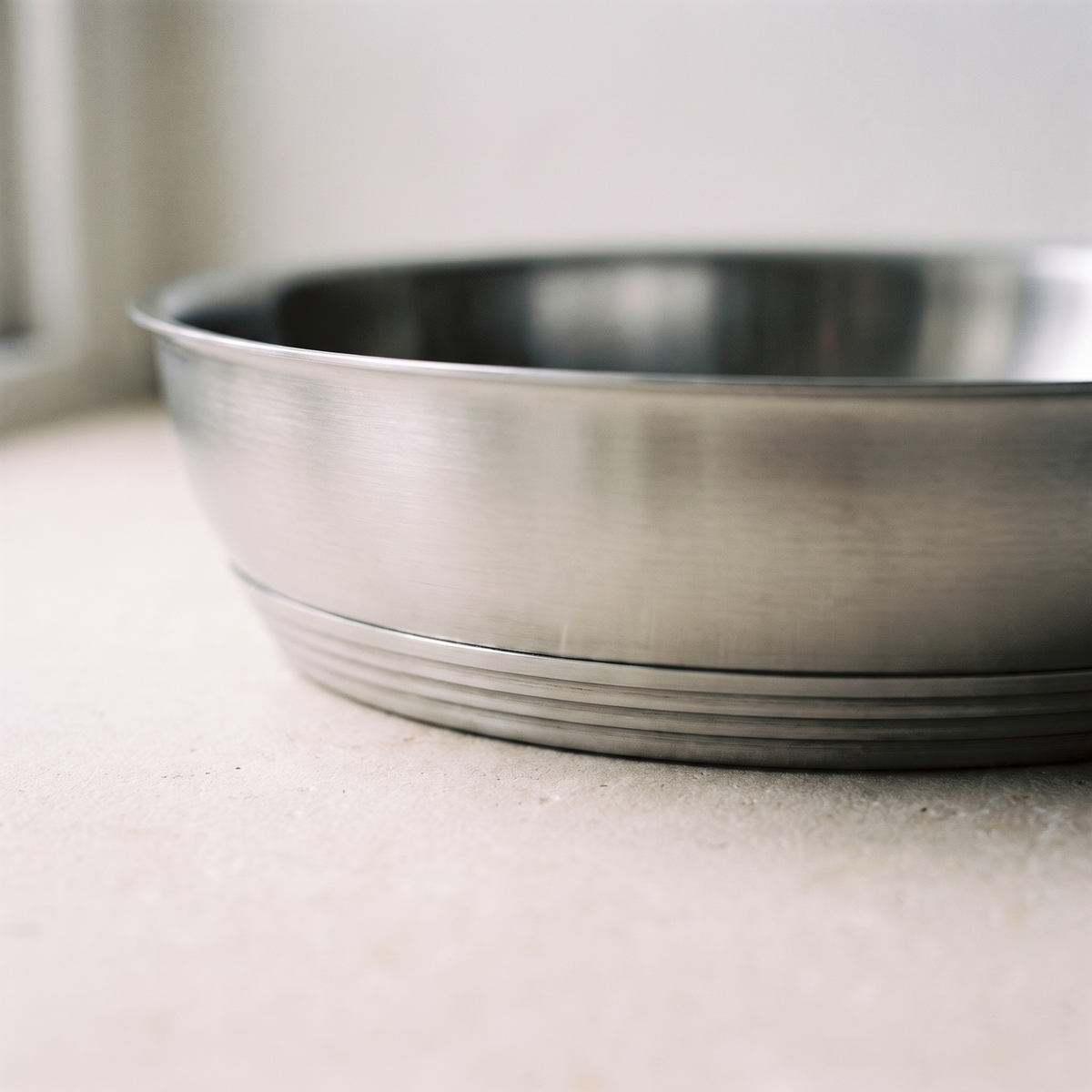 Close view of the thick banded multi layer base and the brushed steel pan wall