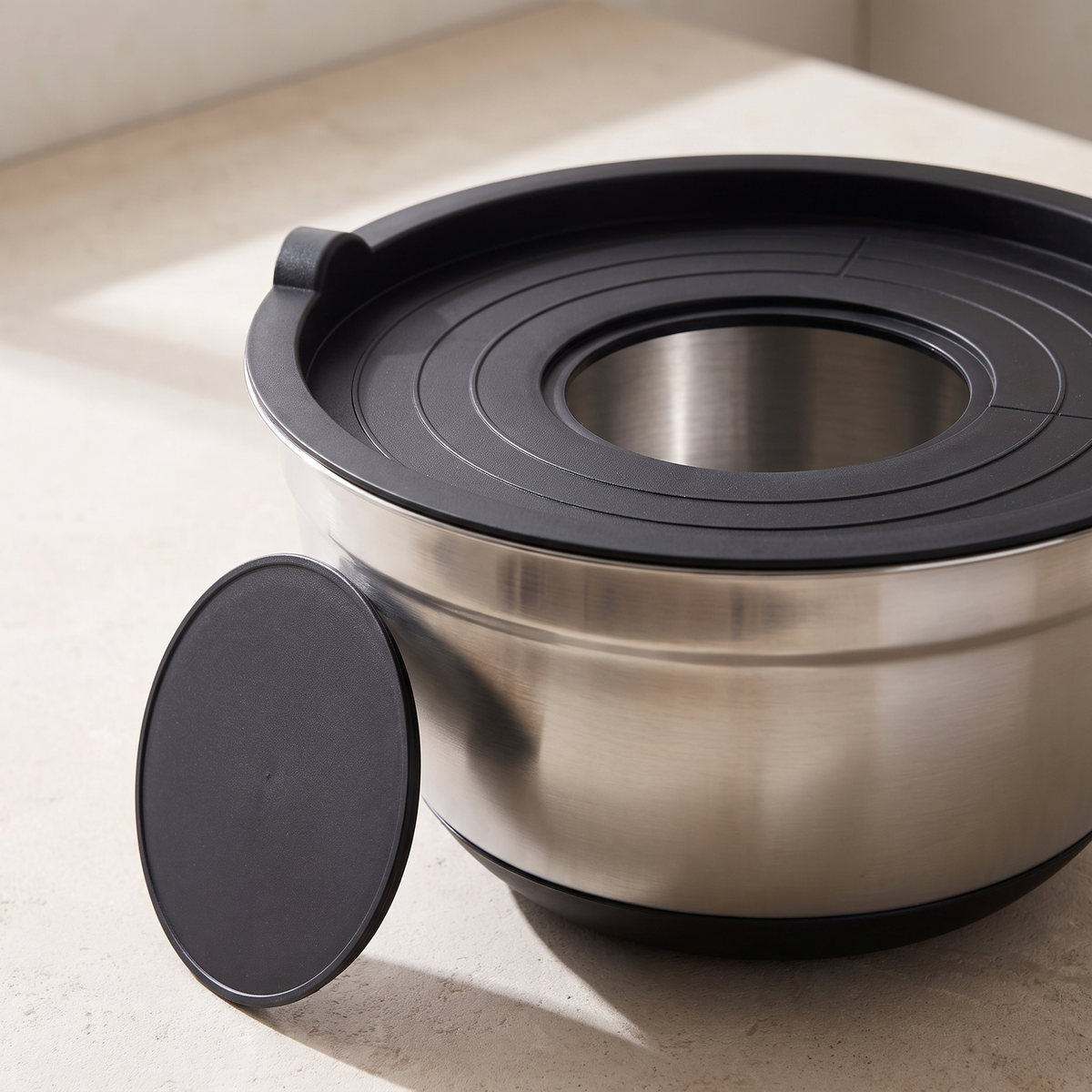 A lid with its round centre panel lifted out, showing the opening it leaves
