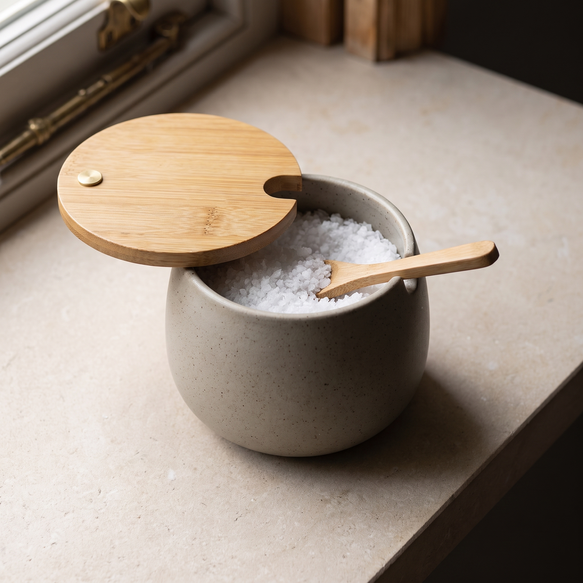 The lid swung open, showing flaked salt and the bamboo spoon inside